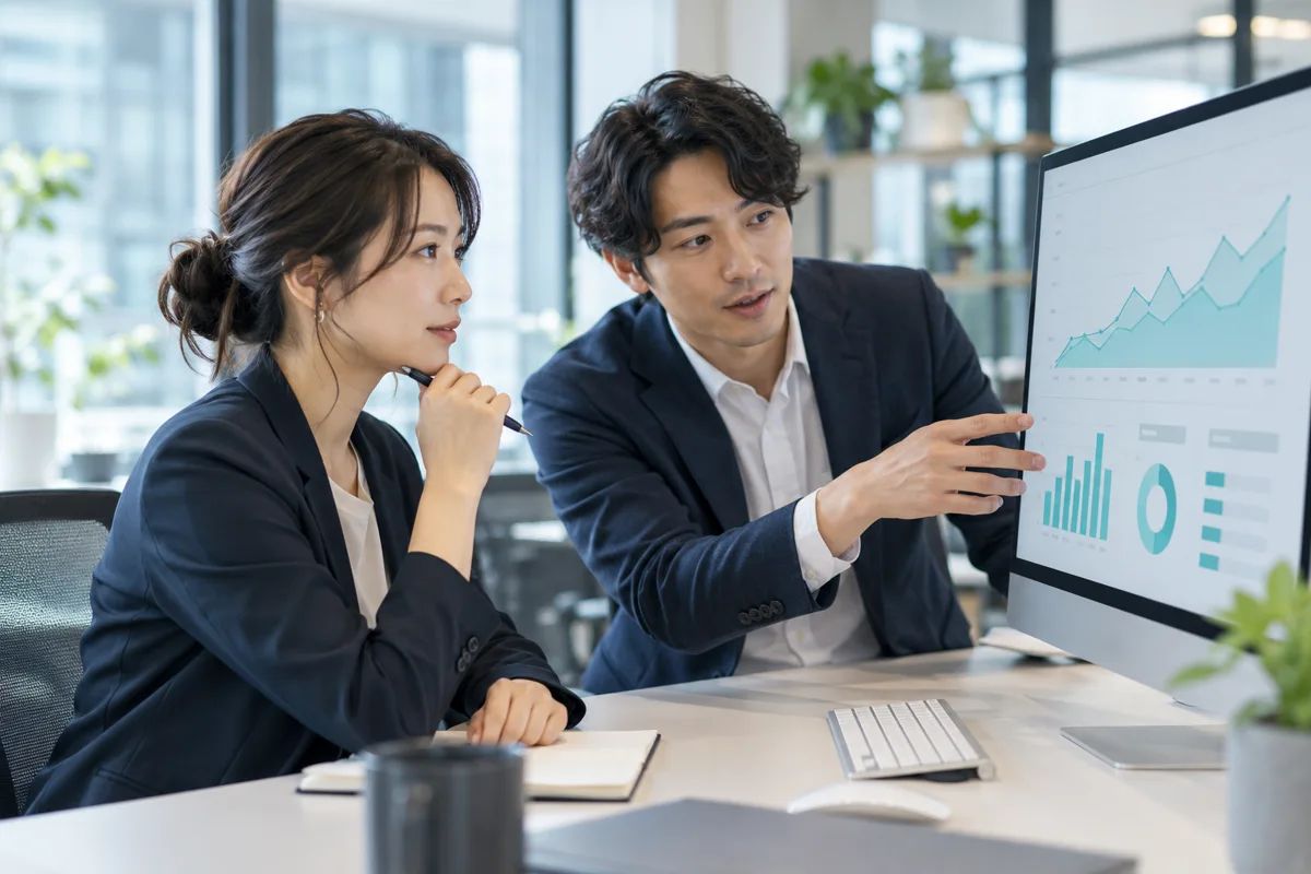 顧客の利用傾向を示す資料を確認し、継続支援について話し合う二人の担当者